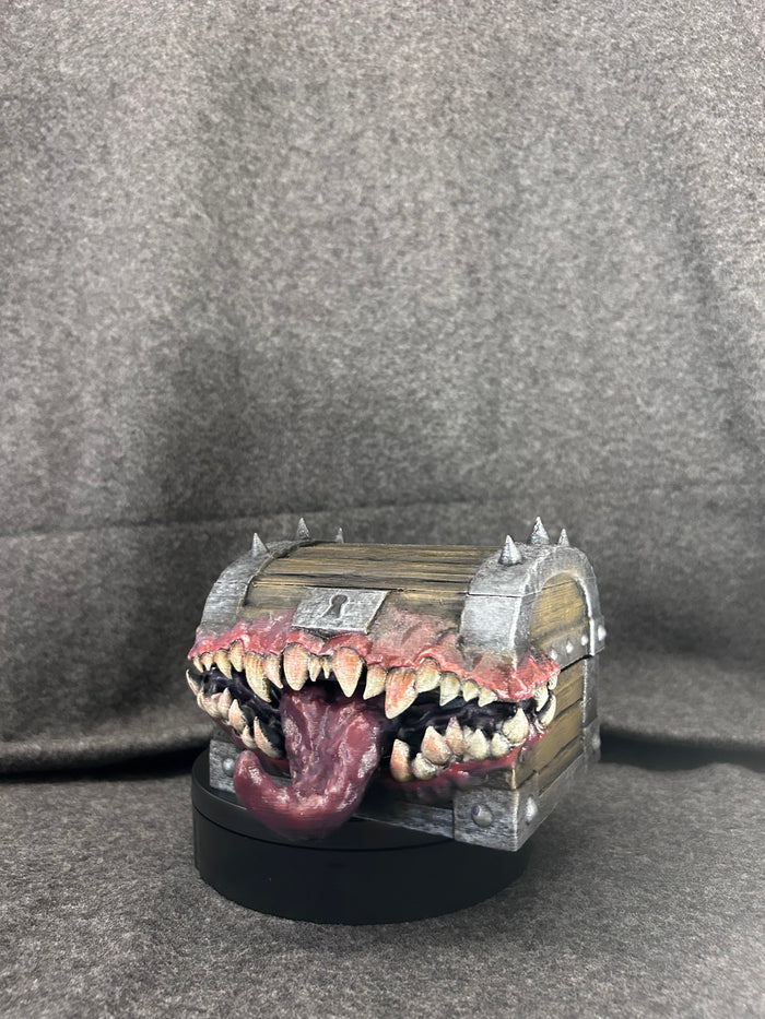 Hand-painted mimic chest in banded timber with a mouth of ivory fangs and a lolling tongue.