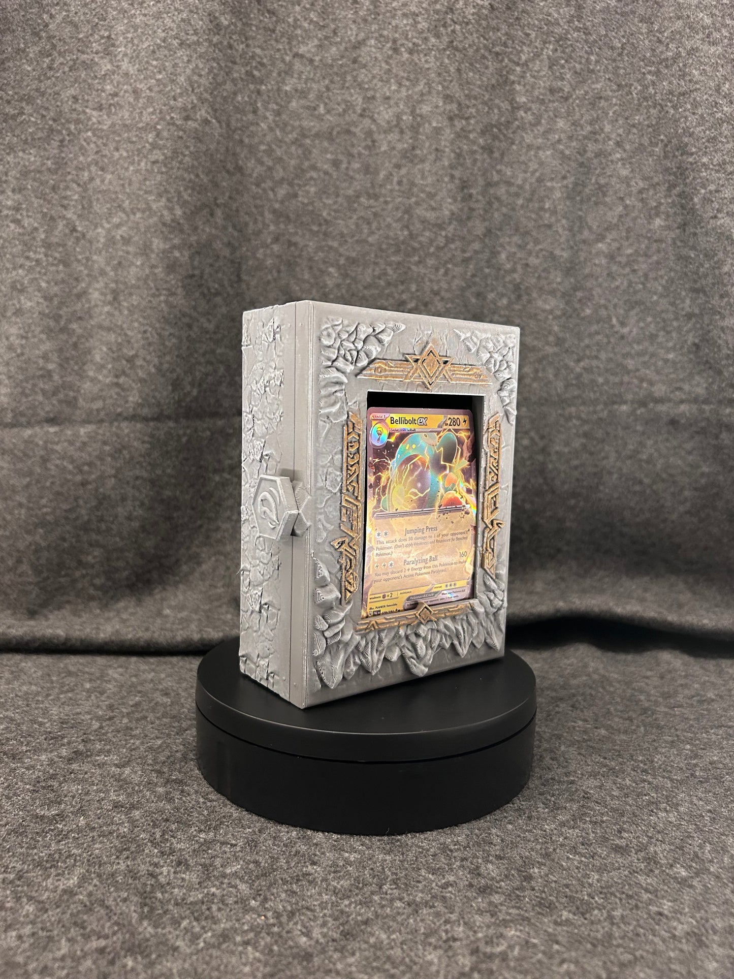 Hand-painted stone card display case with carved runes, framing a single trading card.