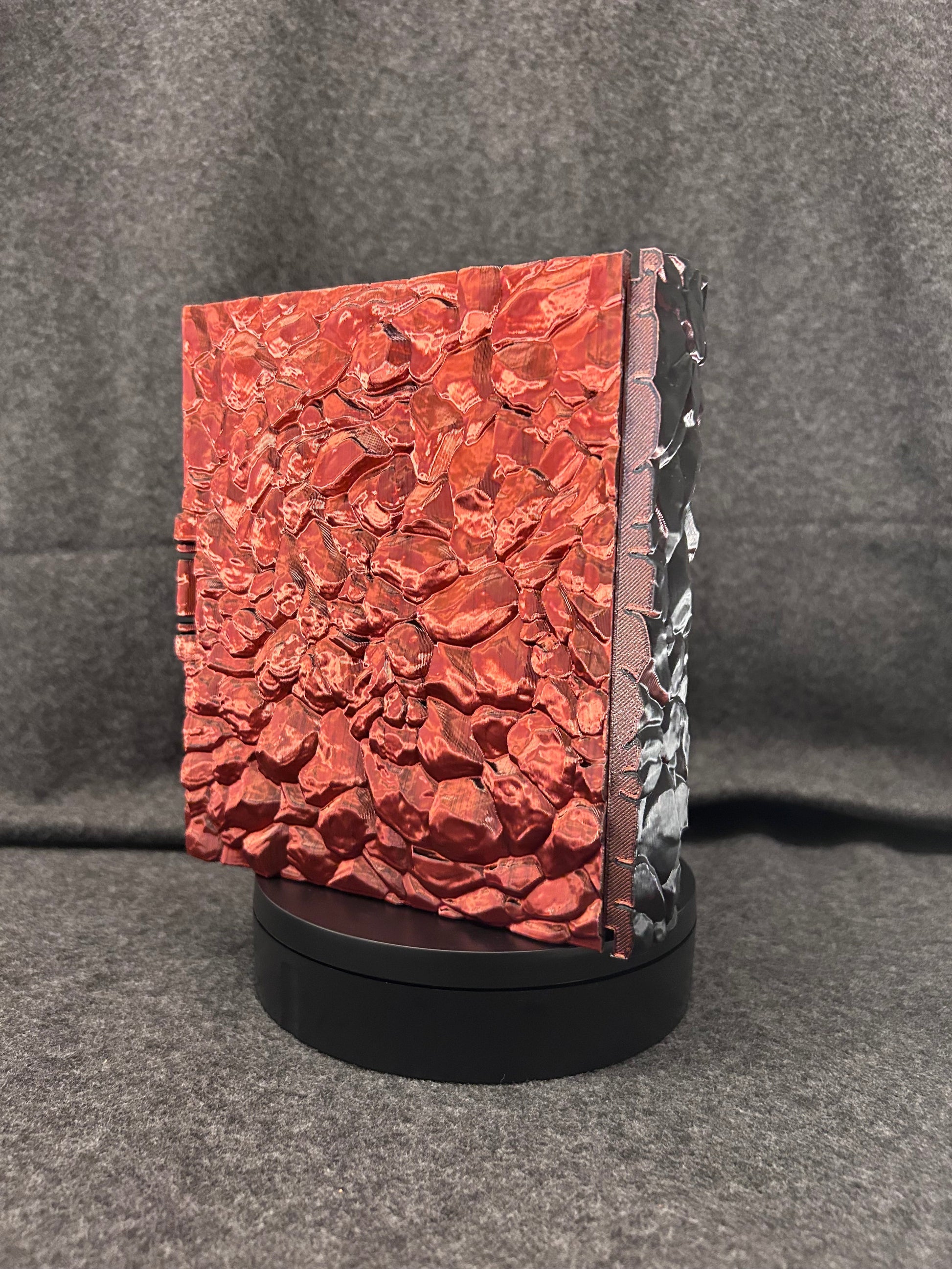 The ember red Wyrmhoard closed, showing the scale texture across the lid.