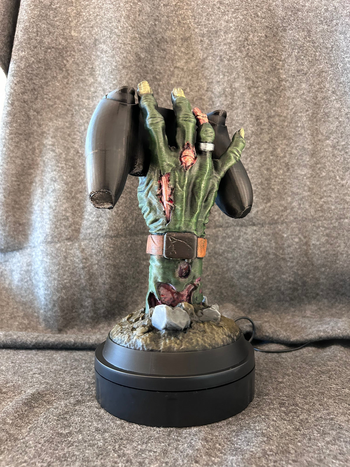 Close view of the painted rot-green skin, split knuckles and beetle detail on the forearm.