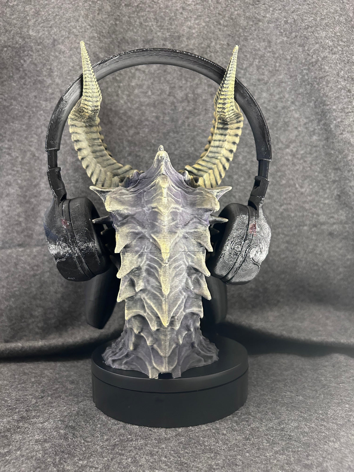 Close view of the hand-painted violet scales, yellow eye and horn banding on the Duskmaw stand.