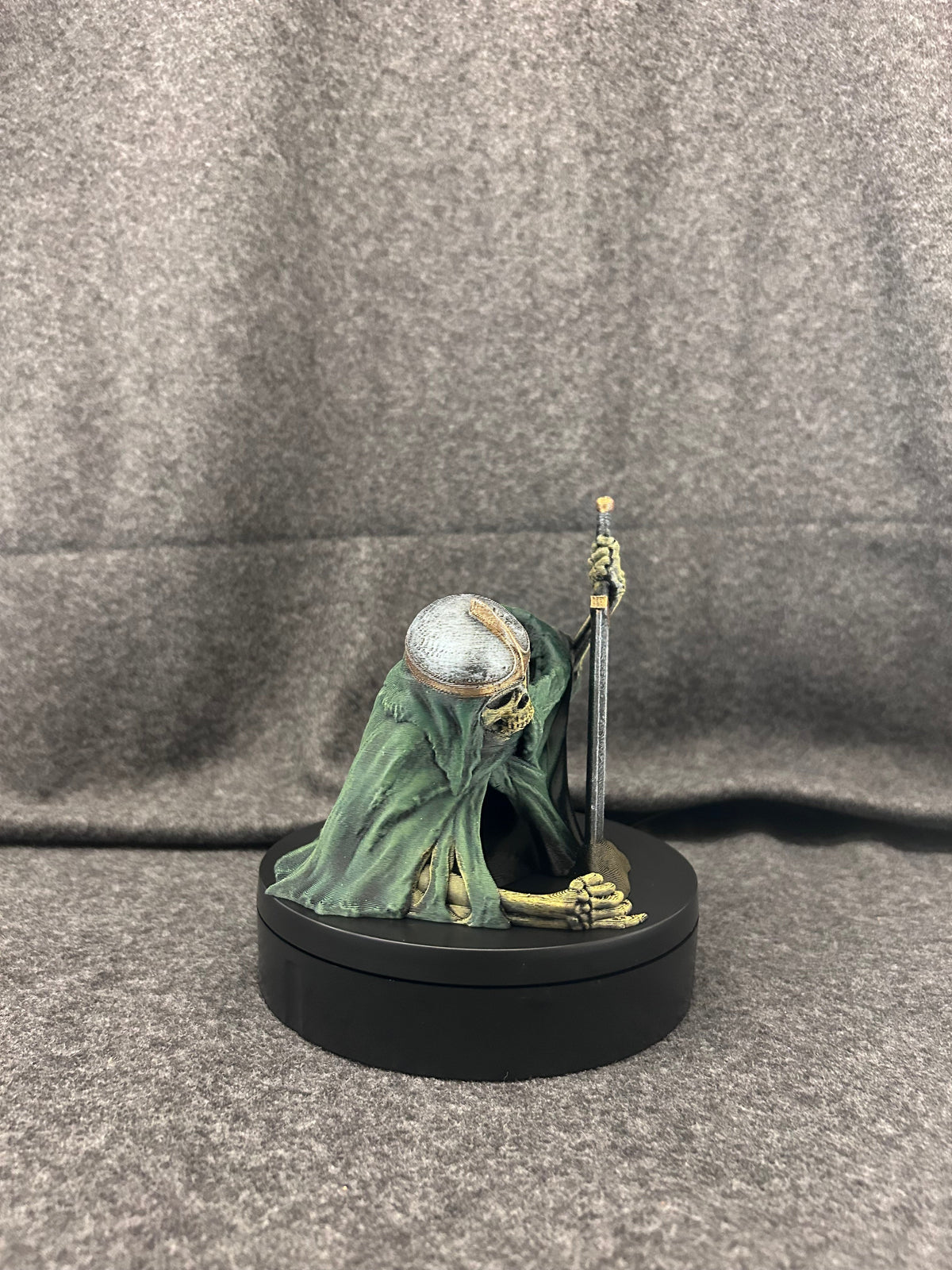 Hand-painted skeletal knight dice tower in deep green robes, gripping a two-handed greatsword, on a black display base.