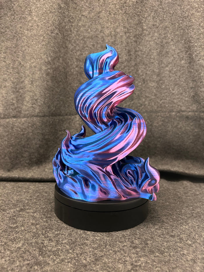 Spiral dice tower printed in blue-to-pink colour-shift filament, twisting up from a black base.