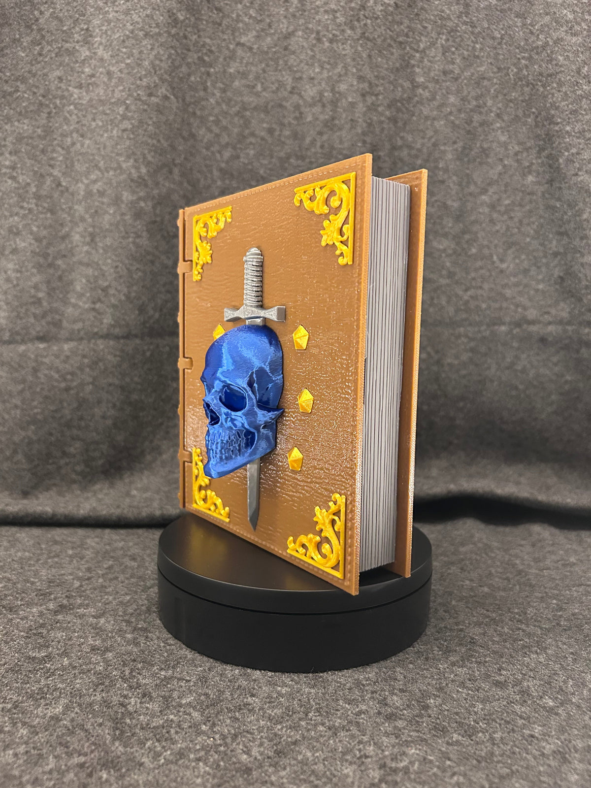 Hand-painted book-shaped deck box hinged open with a stack of sleeved cards inside.