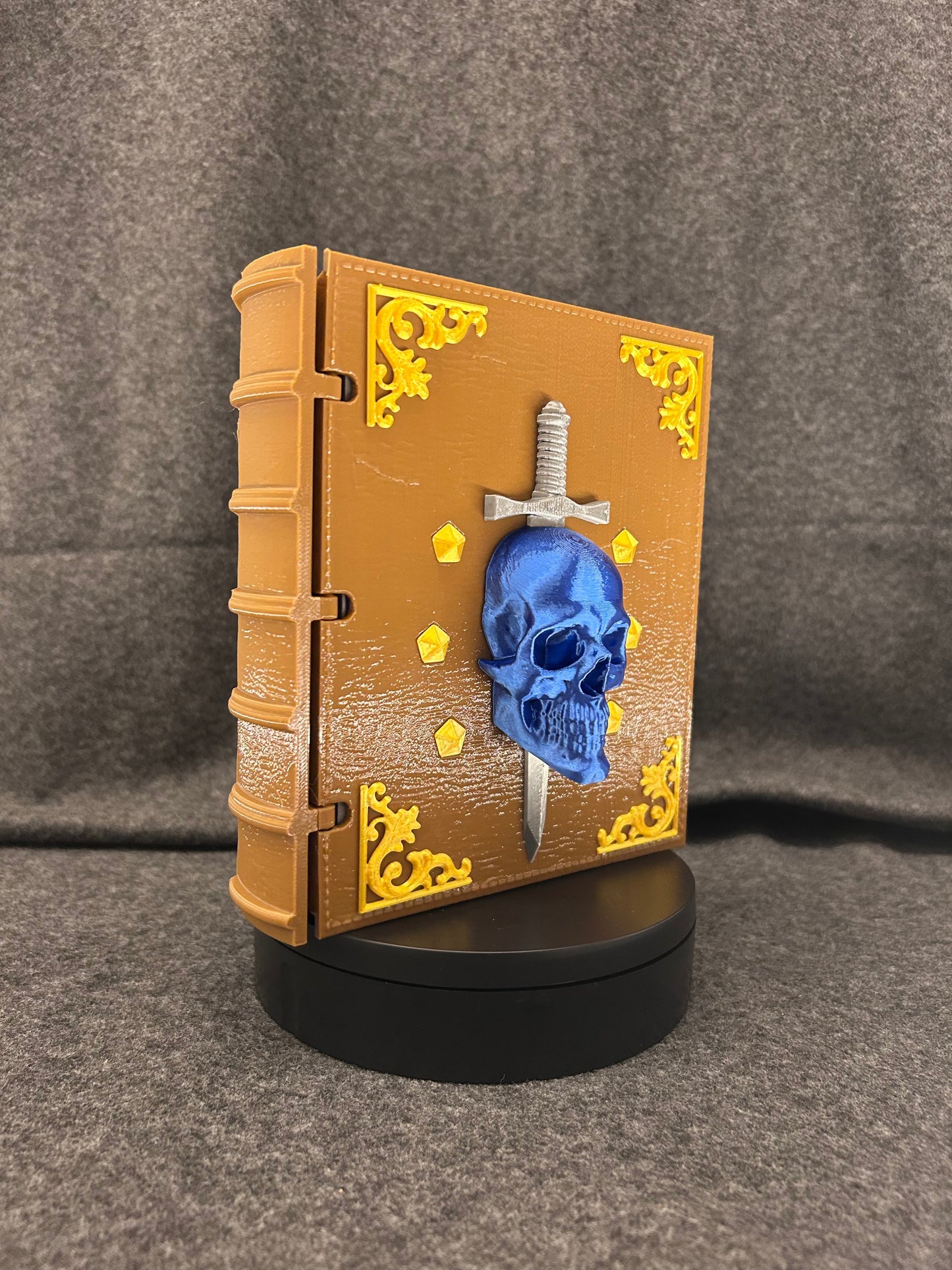The Sworn Grimoire closed, showing the skull-and-sword emblem set into the cover.
