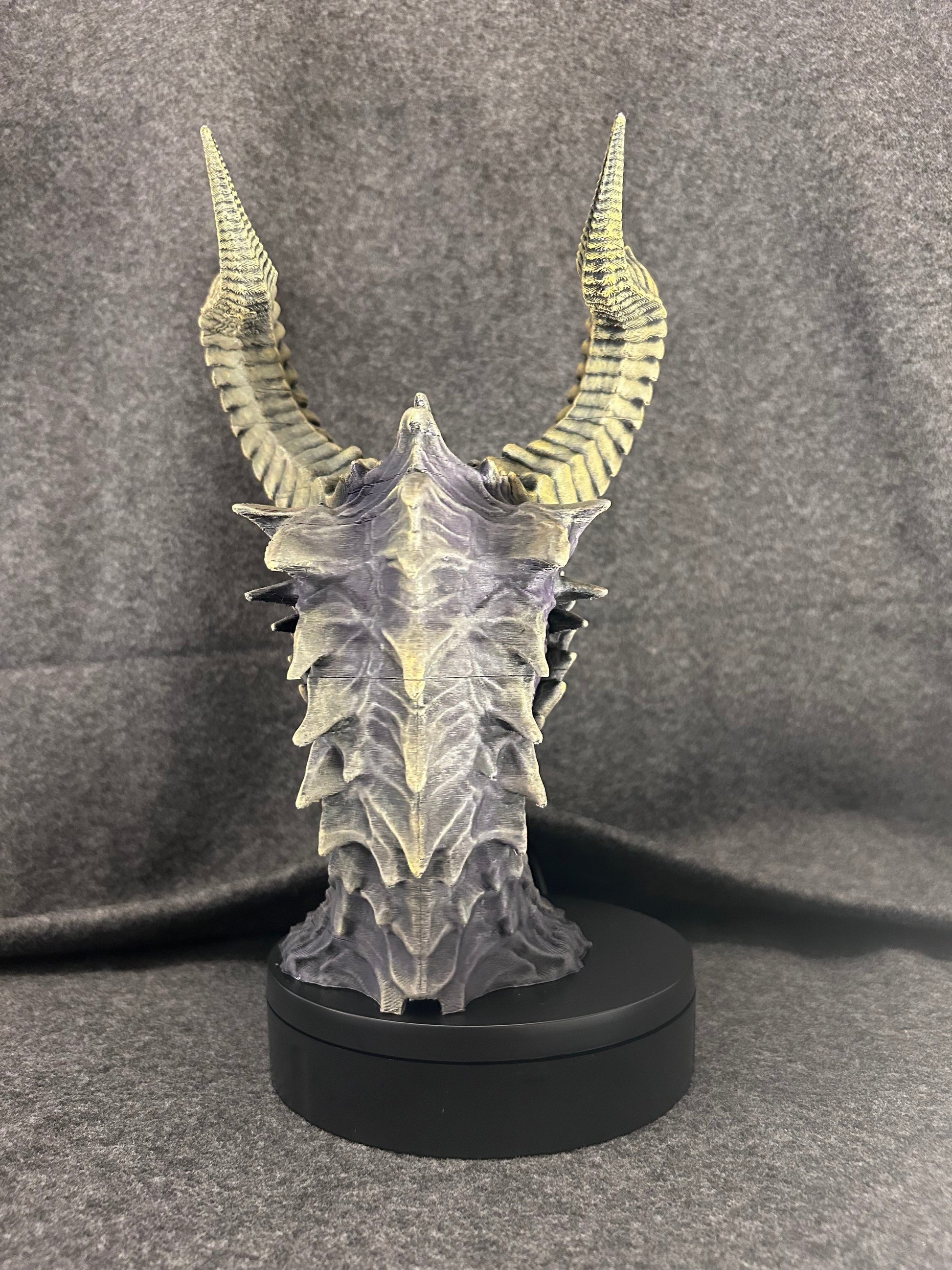 The Duskmaw dragon bust on its weighted base, showing the spined frill along the neck.