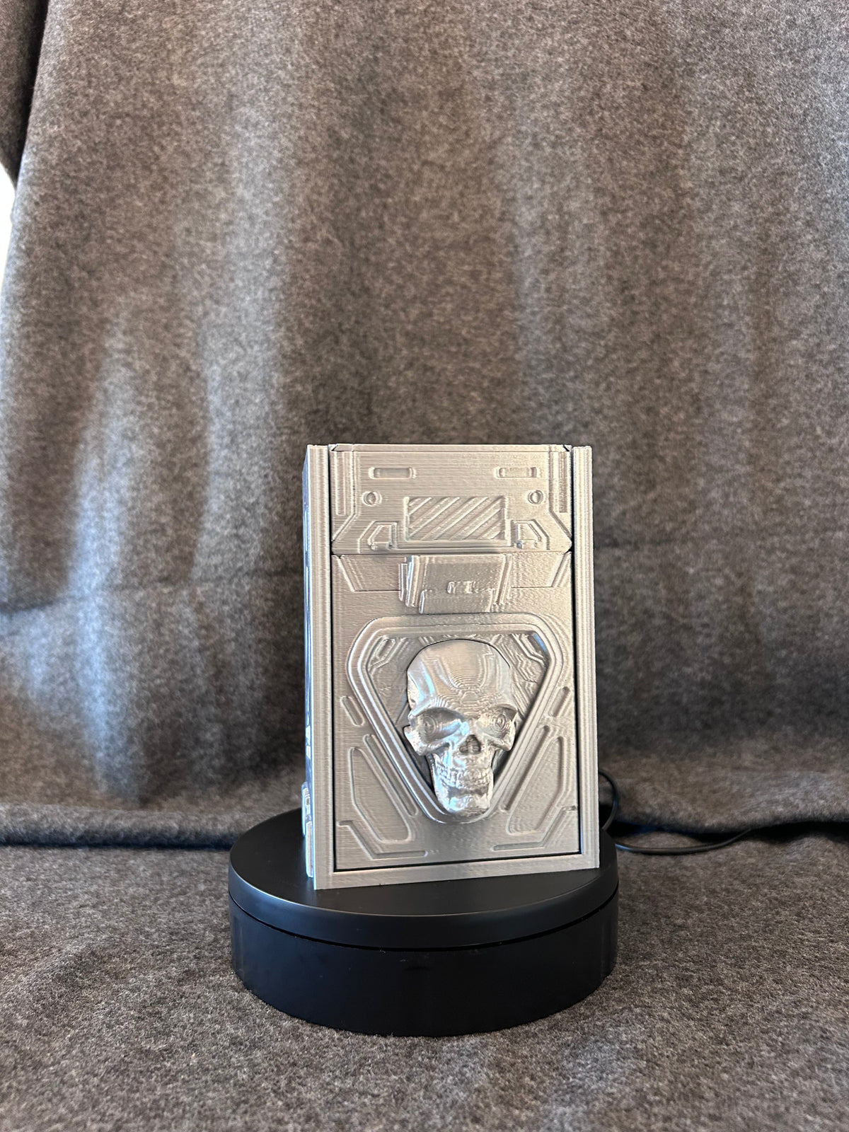 Side view of the Vault Sigma deck box showing the hinged lid and panel lines.