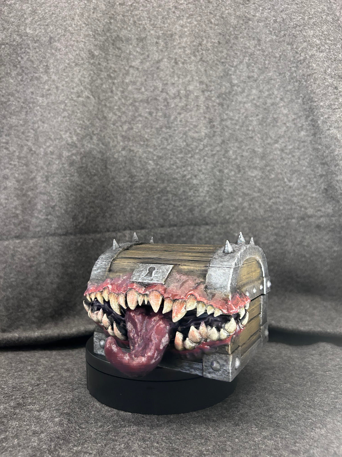 Hand-painted mimic chest in banded timber with a mouth of ivory fangs and a lolling tongue.