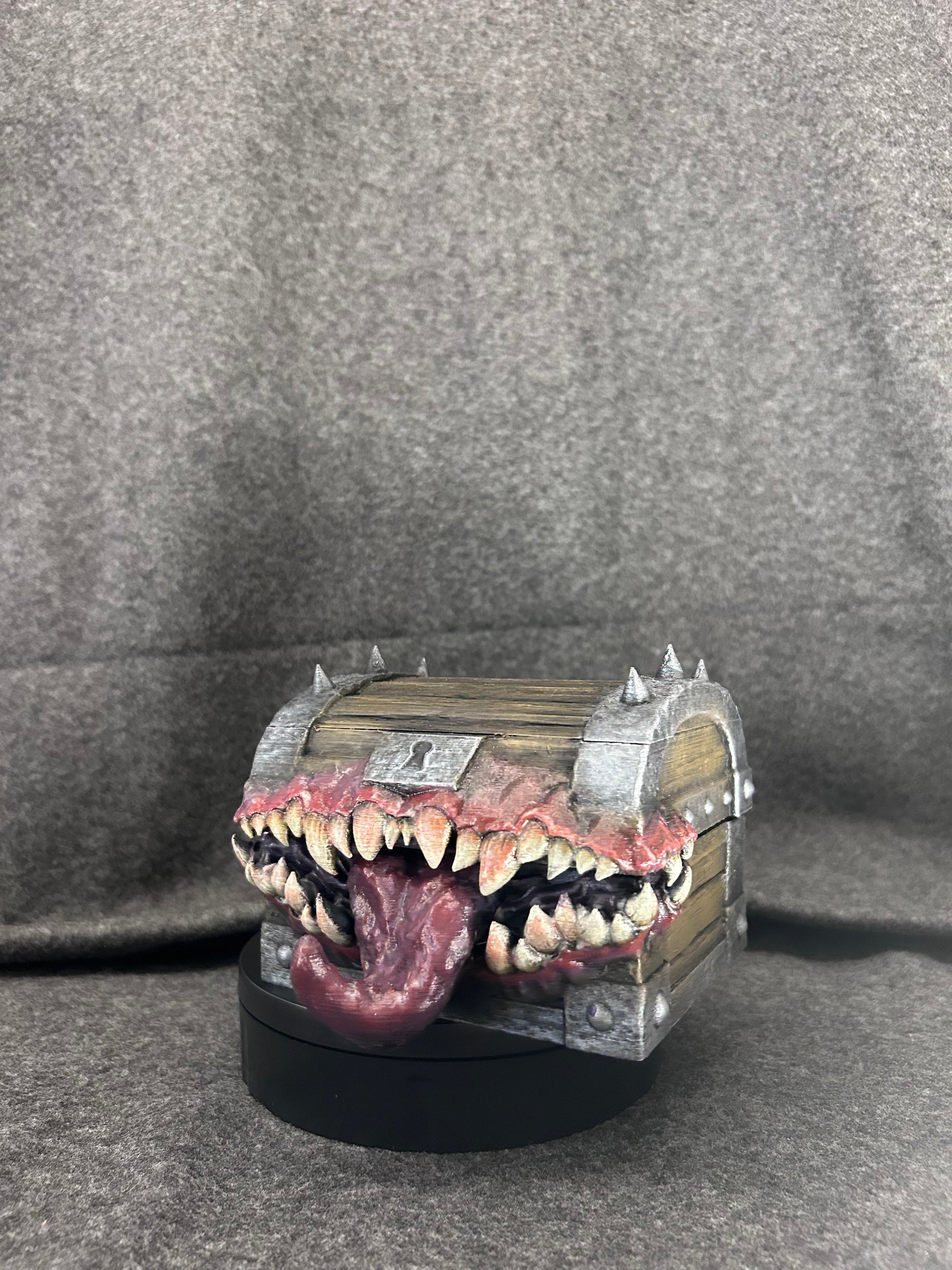 Hand-painted mimic chest in banded timber with a mouth of ivory fangs and a lolling tongue.