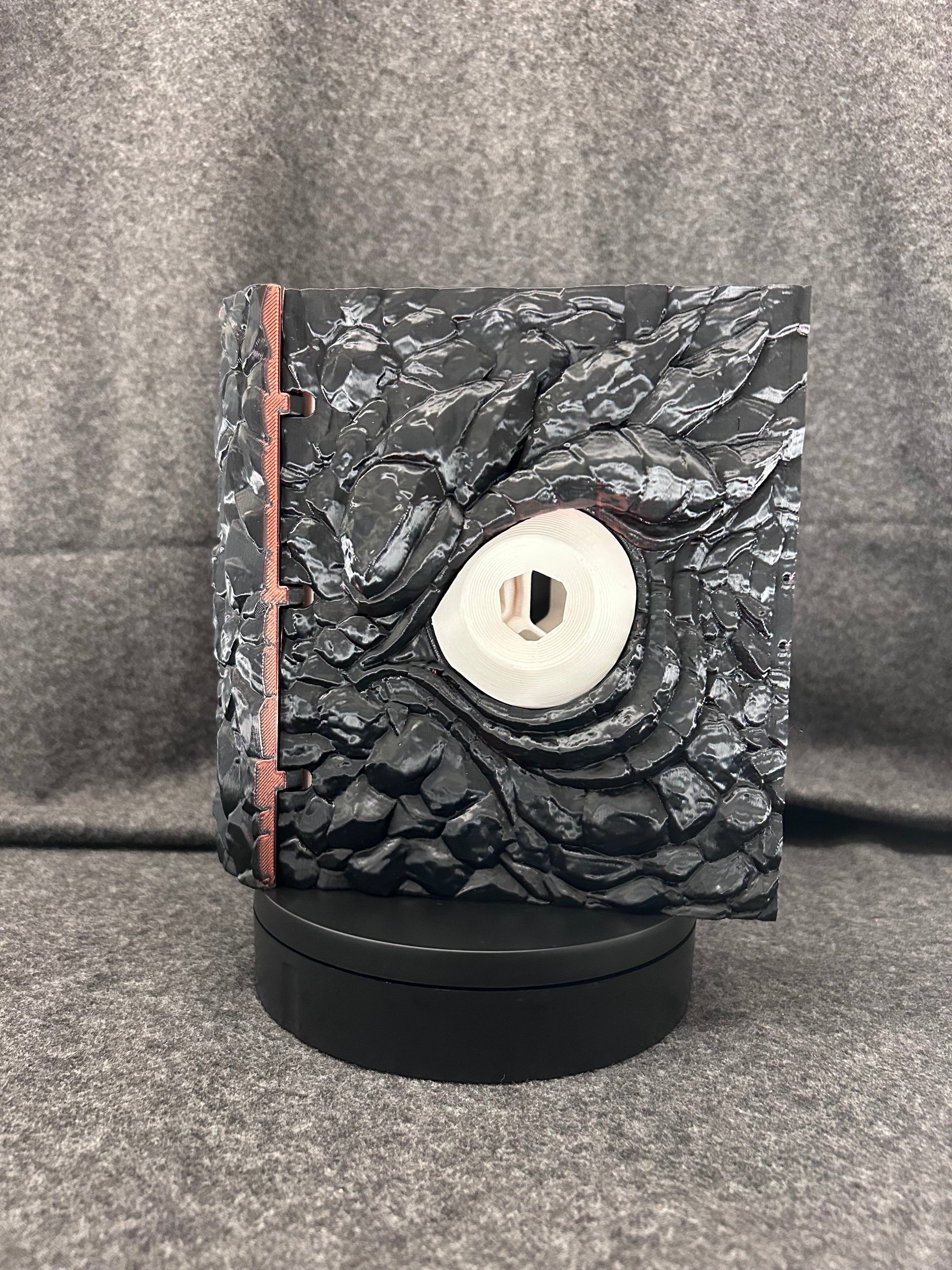 The Wyrmhoard dice case closed, showing the pale spiral shell set into the scaled lid.