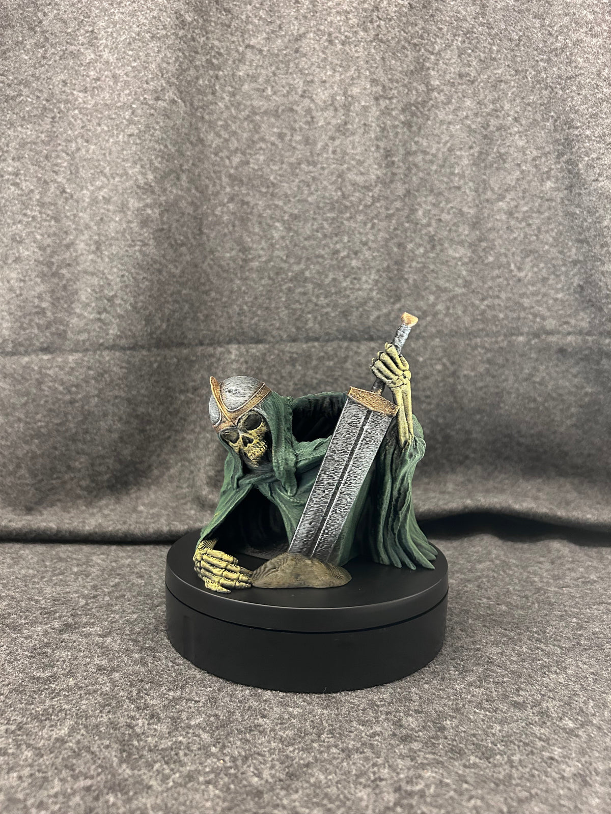 Side view of the skeletal knight dice tower showing the hooded robe folds and gold-trimmed helm.