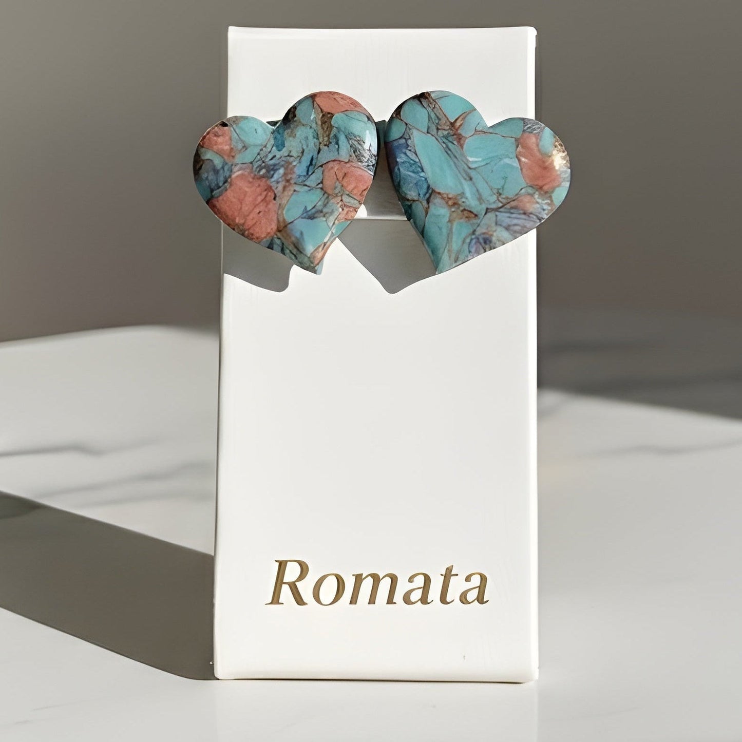 Heart-shaped earrings on a 'Romata' branded card