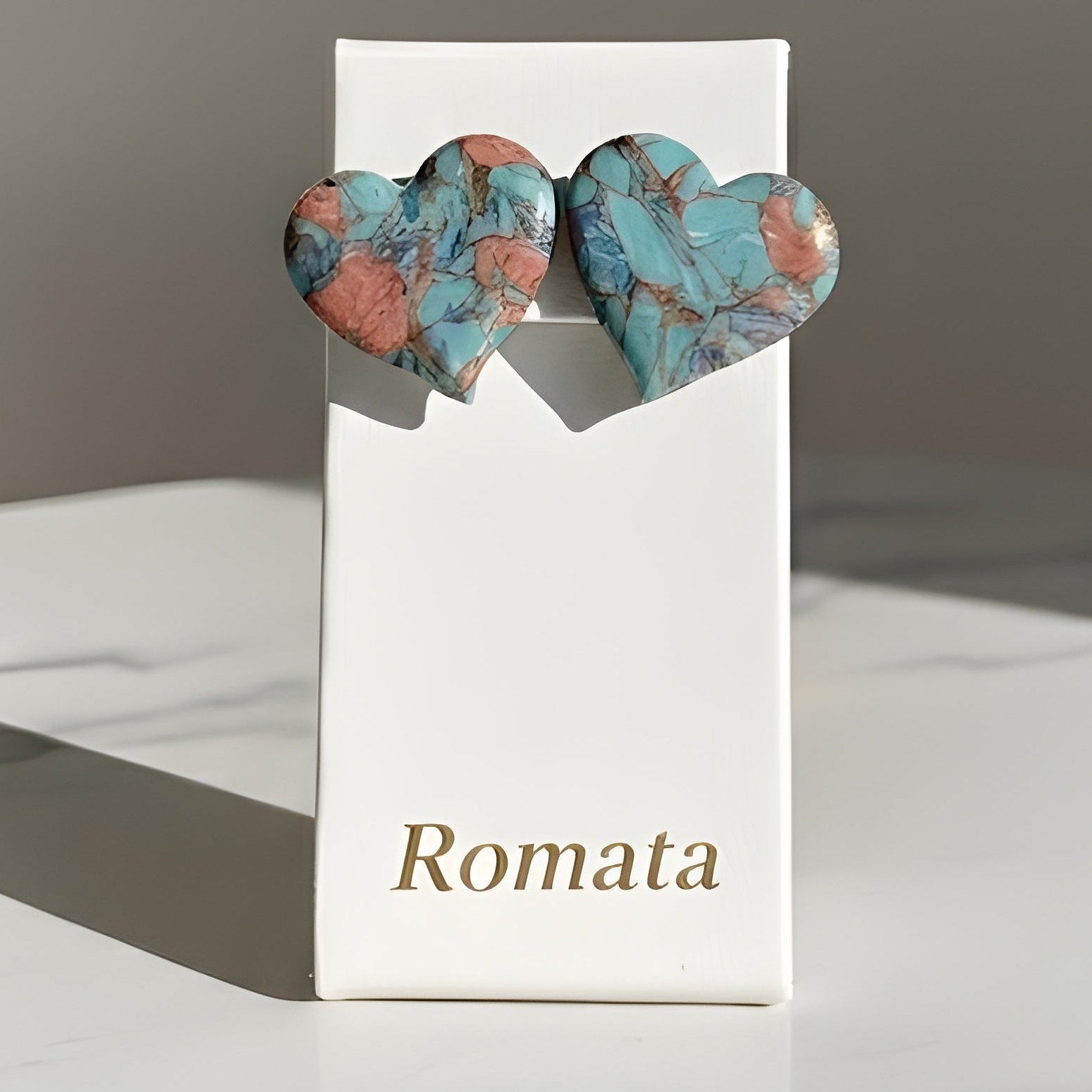 Heart-shaped earrings on a 'Romata' branded card