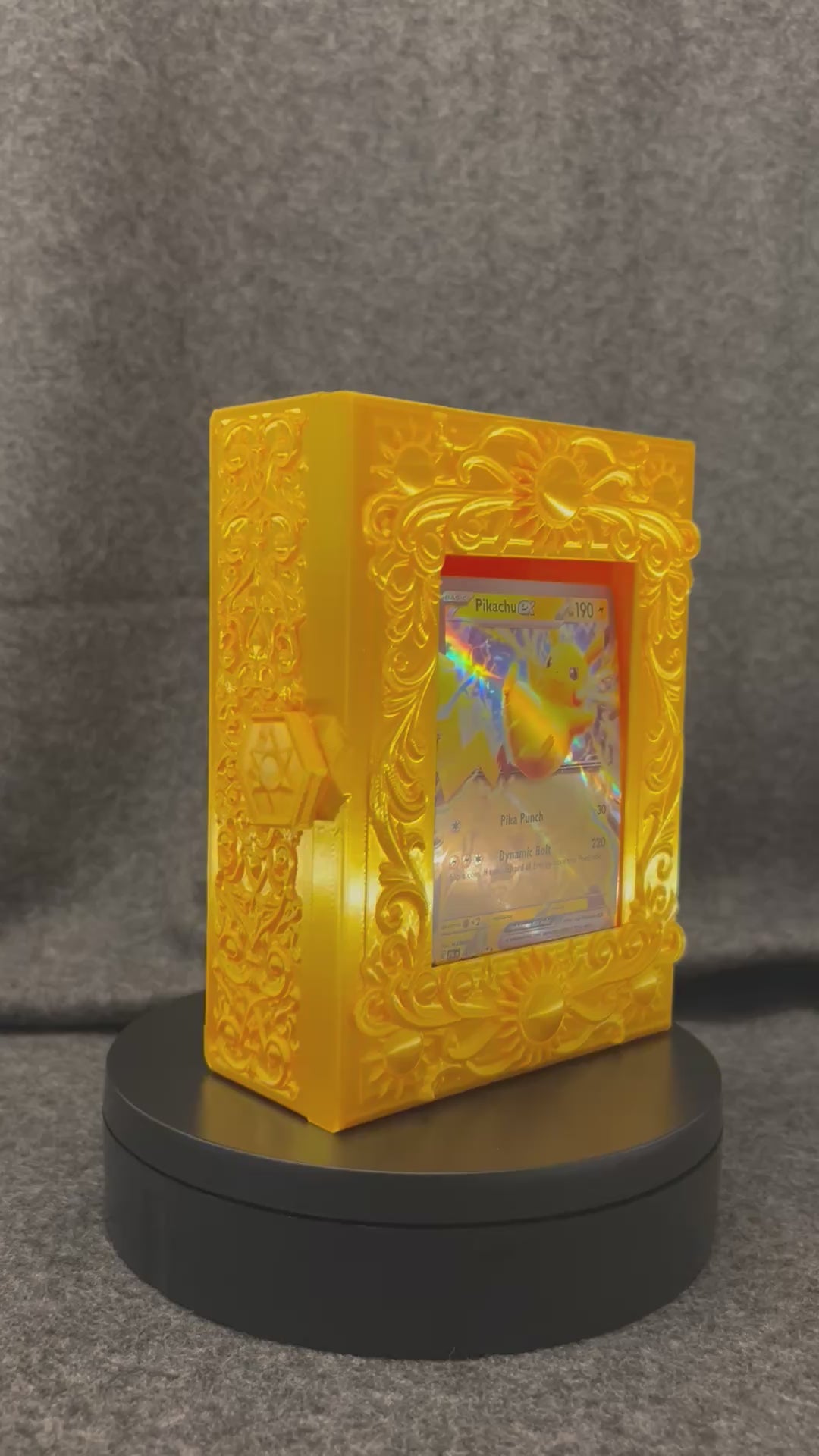 The Gilded Sun Codex turning on a display stand, showing the sun medallions and scrollwork.