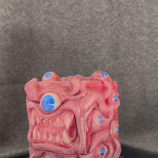 The Ocular Vault deck box turning on a display stand, showing the painted eyes across every fold.