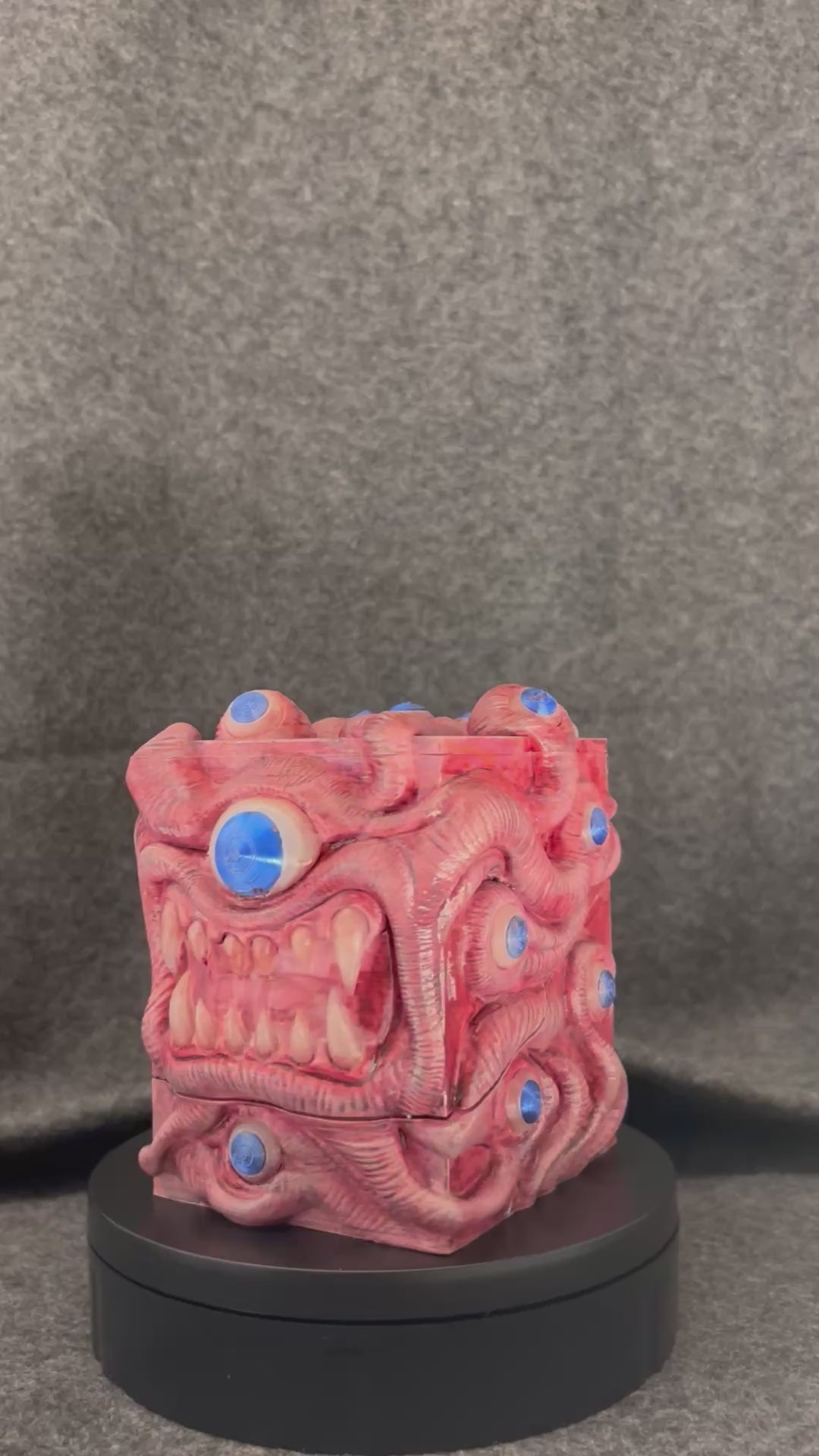 The Ocular Vault deck box turning on a display stand, showing the painted eyes across every fold.