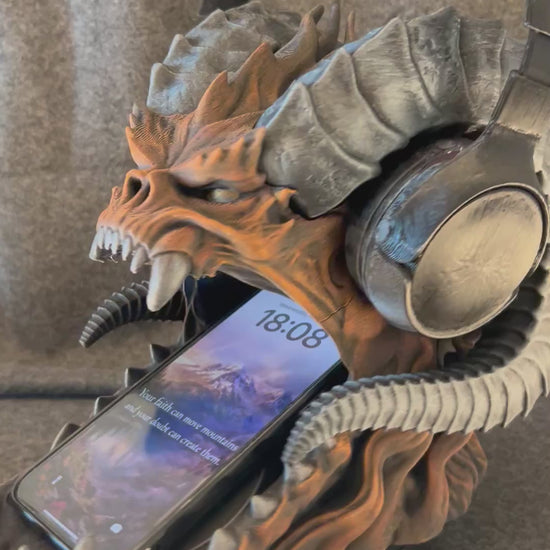 The Warden of the Hoard turning on a display stand, holding a headset on its horns and a phone in its jaws.