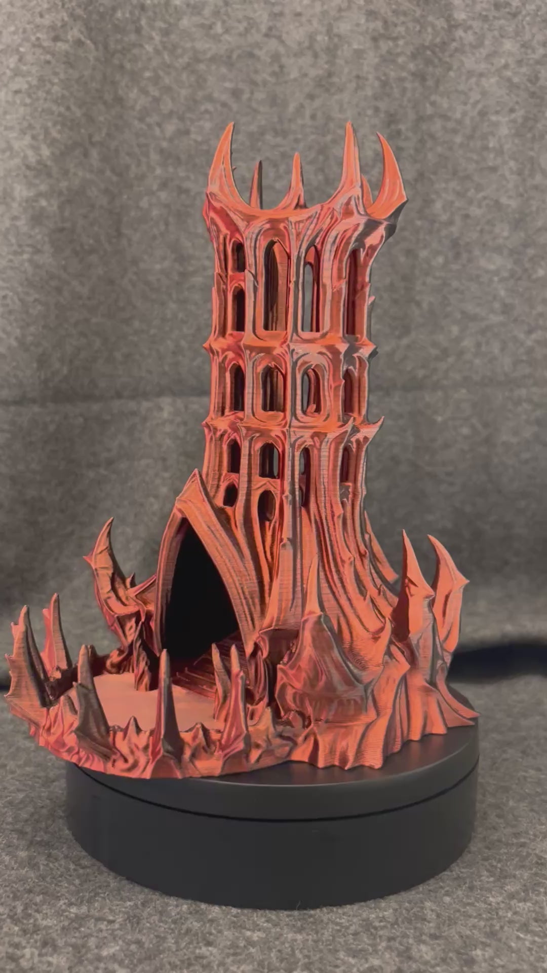 The Vespers gothic dice tower turning on a display stand, showing the pierced arch windows from every side.