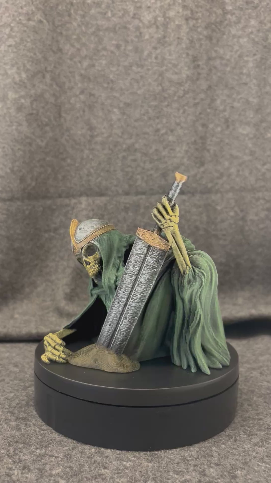 The Last Oath dice tower turning on a display stand, showing the robed skeletal knight and greatsword.