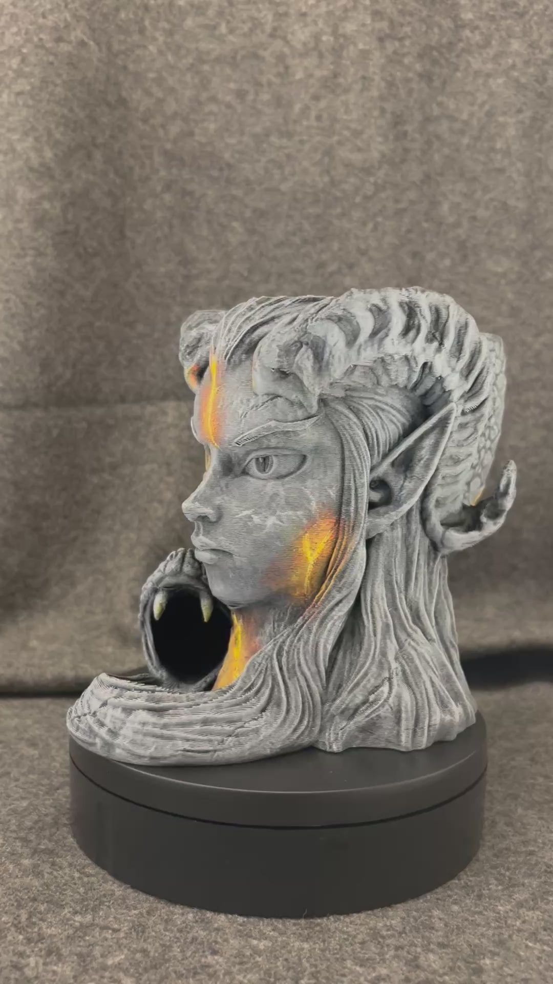 The Serpent Oracle turning on a display stand, showing the carved stone face and the coiled serpent.