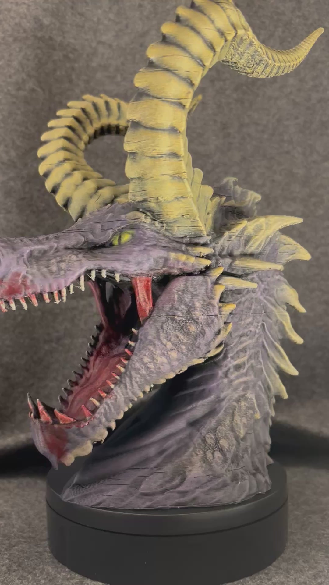 Duskmaw dragon bust turning on a display stand, showing the controller in its jaws and the headset on its horns.