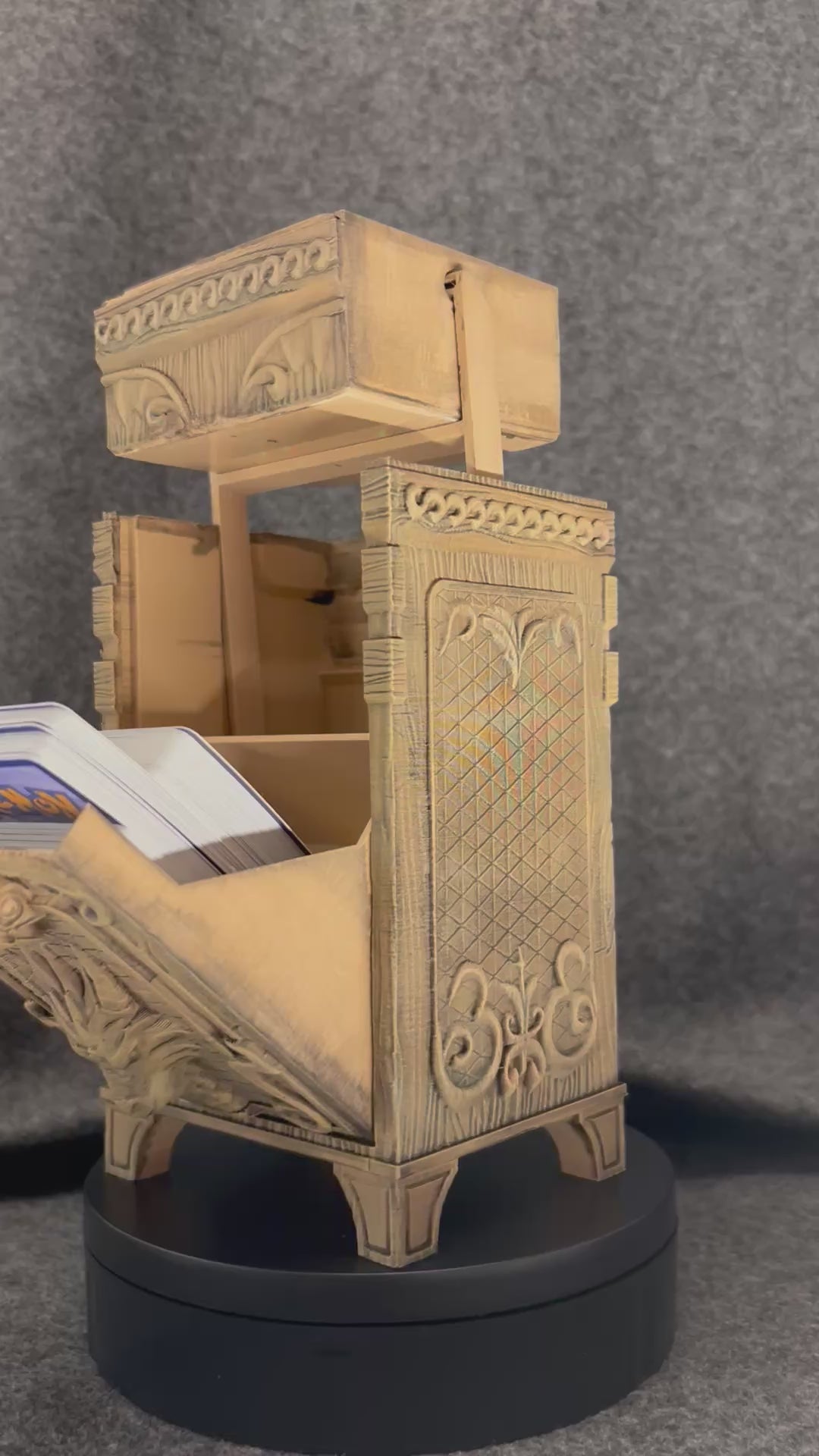 The Antiquarian deck chest turning on a display stand, showing the carved panels and lift-off lid.